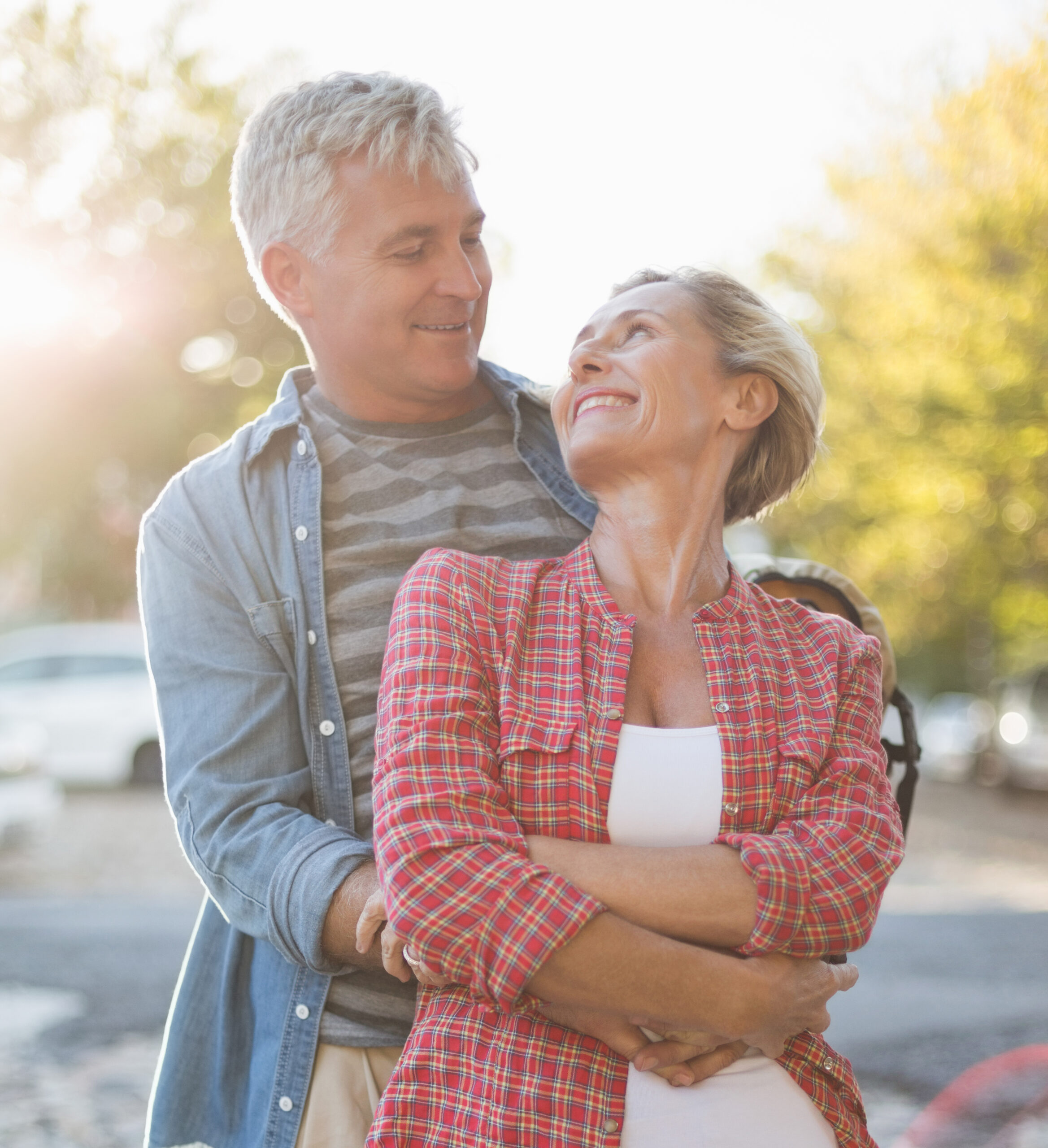 Happy mature couple hugging in the city on a sunny day Happy mature couple hugging